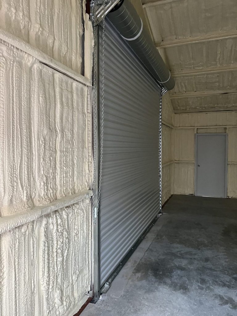 Roll-up door in a metal shop insulated with spray foam